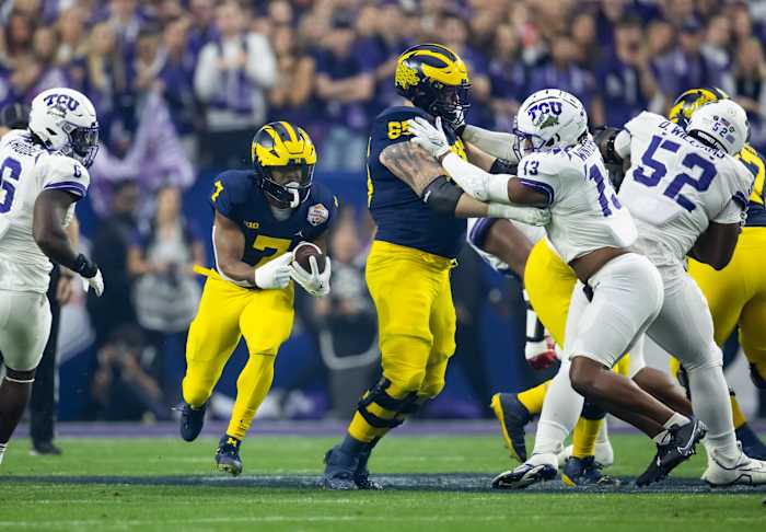 Dec 31, 2022; Glendale, Arizona, USA; Michigan Wolverines running back Donovan Edwards (7) runs the ball as offensive lineman Zak Zinter (65) blocks TCU Horned Frogs linebacker Dee Winters (13) during the 2022 Fiesta Bowl at State Farm Stadium. Mandatory Credit: Mark J. Rebilas-USA TODAY Sports